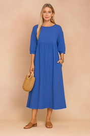 midi dress featuring three-quarter puff sleeves, a high gathered waistline, and a relaxed A-line silhouette