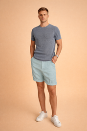 Light aqua linen shorts with a tailored straight cut, mid-thigh length, soft breathable woven texture, subtle natural fiber grain, clean front panel without pockets, neatly folded hem cuffs, and an even pastel aqua tone with consistent color depth and no pattern variation.