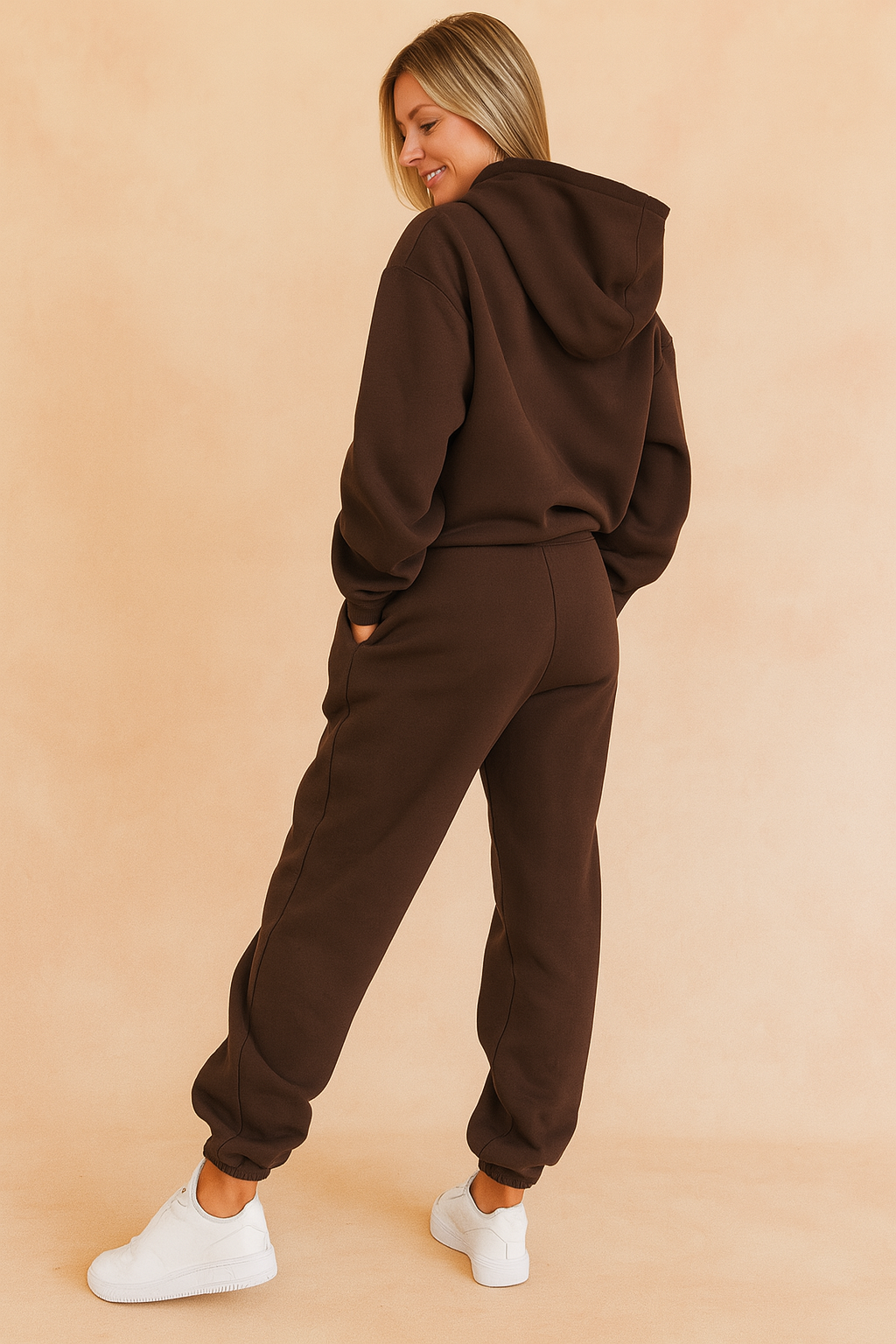 Back view of a dark brown hoodie and jogger co-ord set with elasticated cuffs and relaxed seams, styled for a clean and sporty silhouette paired with white sneakers.