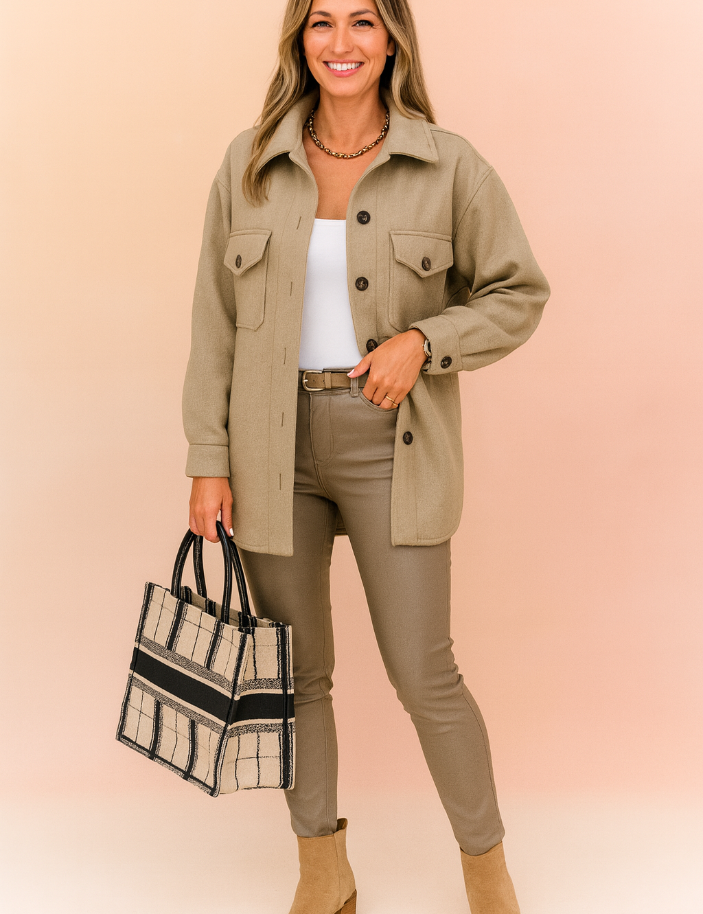Beige button-up shacket jacket with front flap pockets, styled over a white top and slim-fit taupe pants, paired with a plaid structured tote bag and suede ankle boots.