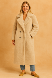 Long beige teddy coat with wide lapel collar, double-breasted button closure, and full-length cut for winter wear