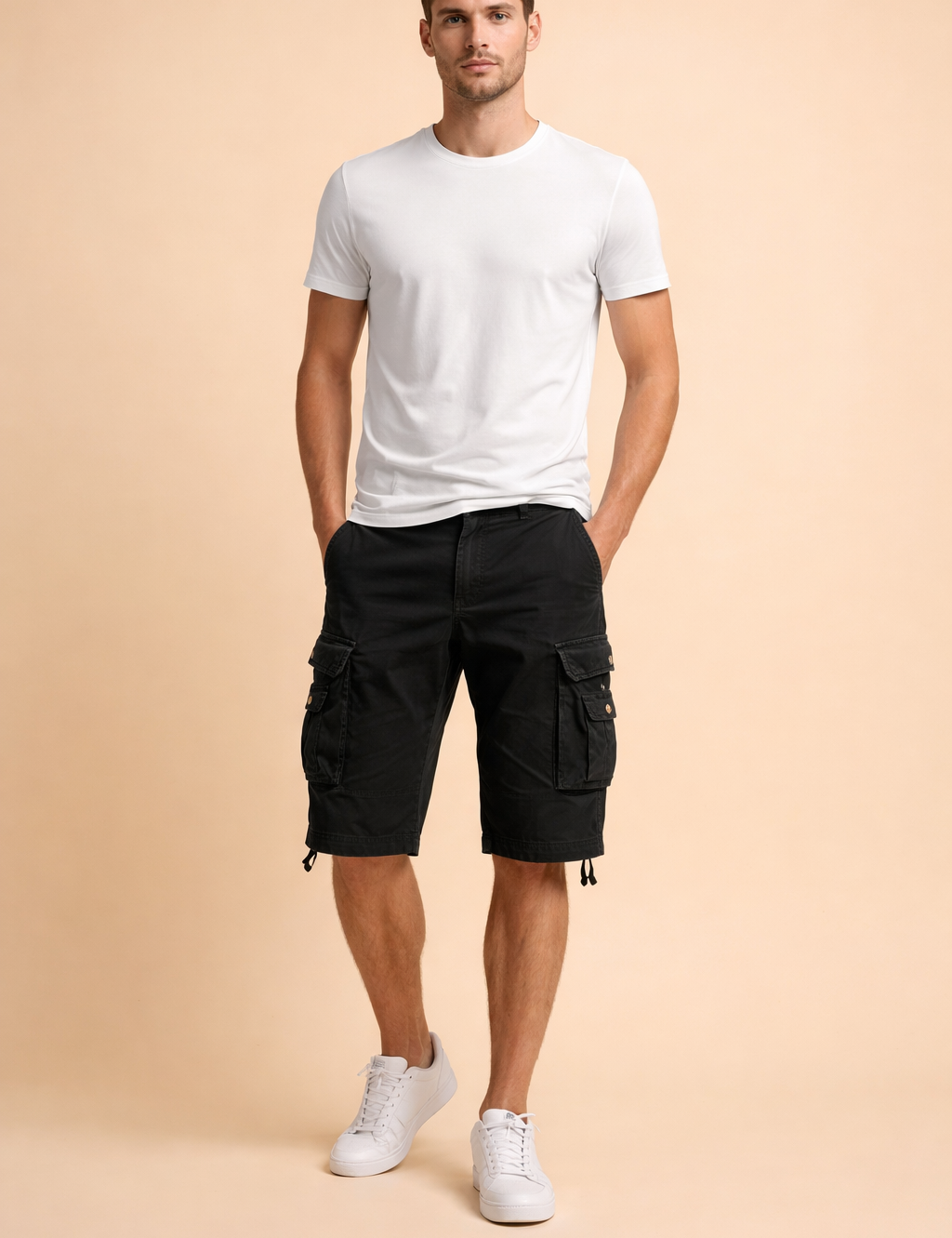 Black cotton cargo shorts with flap pockets and button details, styled with a clean white short-sleeve crew neck t-shirt and white low-top sneakers, showcasing a structured casual summer outfit with a matte fabric finish and precise stitching.