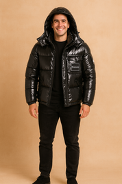 Glossy black Monoler puffer jacket with hood, front zipper, and chest logo patch, styled with black jeans and sneakers.