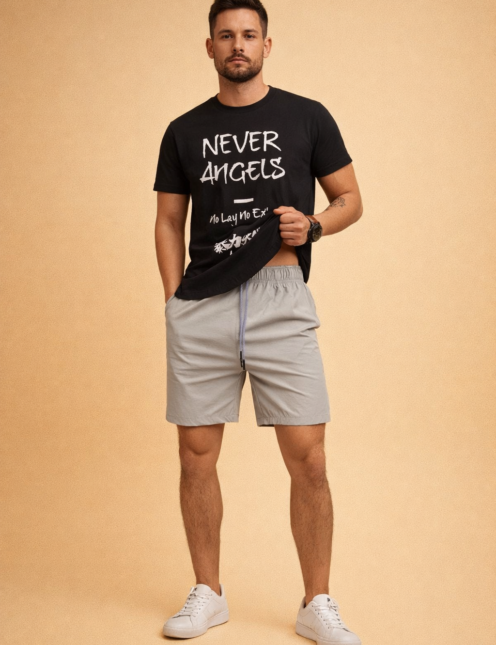 Black graphic crew-neck T-shirt with bold white Never Angels lettering and Japanese-style print, paired with light grey elastic-waist men’s shorts featuring a smooth matte fabric, subtle seam detailing, and matching grey drawstring, styled with clean white low-top sneakers.