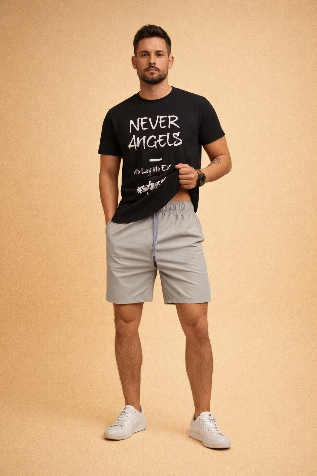 Black graphic crew-neck T-shirt with bold white Never Angels lettering and Japanese-style print, paired with light grey elastic-waist men’s shorts featuring a smooth matte fabric, subtle seam detailing, and matching grey drawstring, styled with clean white low-top sneakers.