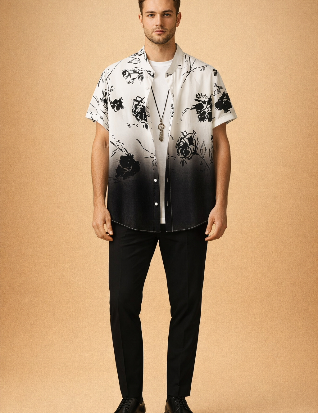Black and white gradient short sleeve button-up shirt with black floral print, layered over a plain white crew neck t shirt, paired with slim black trousers, black leather lace-up shoes, and a minimalist pendant necklace