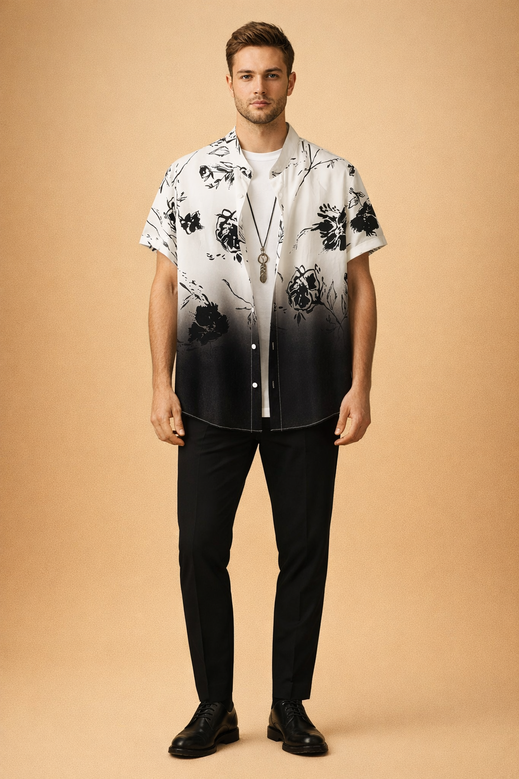 Black and white gradient short sleeve button-up shirt with black floral print, layered over a plain white crew neck t shirt, paired with slim black trousers, black leather lace-up shoes, and a minimalist pendant necklace