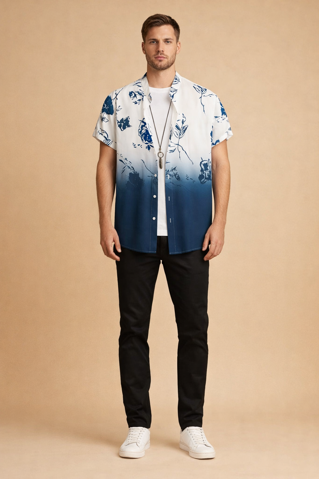Short-sleeve button-up shirt with a white-to-deep blue gradient and abstract floral print, layered over a plain white crew-neck T-shirt, paired with slim black trousers and clean white low-top sneakers, showcasing a relaxed modern casual outfit with precise tailoring and smooth fabric drape.