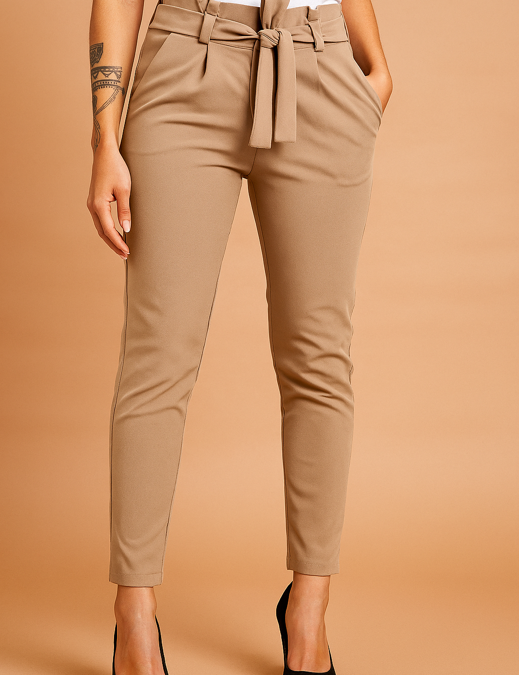 Tailored brown paperbag pants with high waist, pleats, and belt tie, styled with side pockets and tapered legs for a polished everyday look.