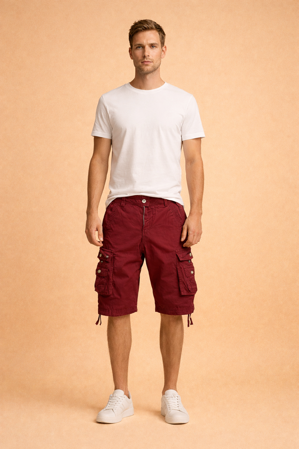 Burgundy cotton cargo shorts with multi-pocket utility design, metal snap buttons, adjustable drawstring hems, paired with a plain white short-sleeve crew-neck cotton T-shirt and clean white low-top sneakers
