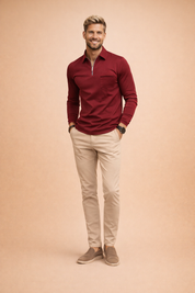 Burgundy long-sleeve quarter-zip top with a clean stand collar and subtle chest zip detail, paired with slim-fit beige trousers and taupe slip-on loafers for a refined smart-casual look.