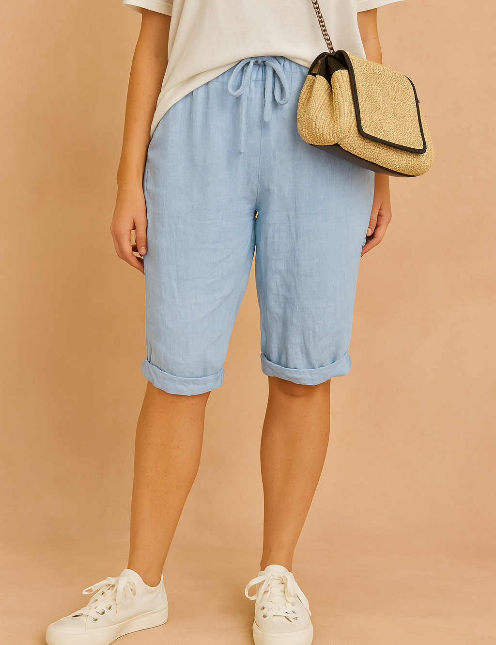 Light blue knee-length drawstring shorts with rolled cuffs, styled with a casual white T-shirt and white lace-up sneakers.