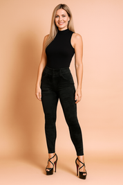 High-waisted black velvet leggings with subtle distressed details, paired with black strappy stiletto heels.