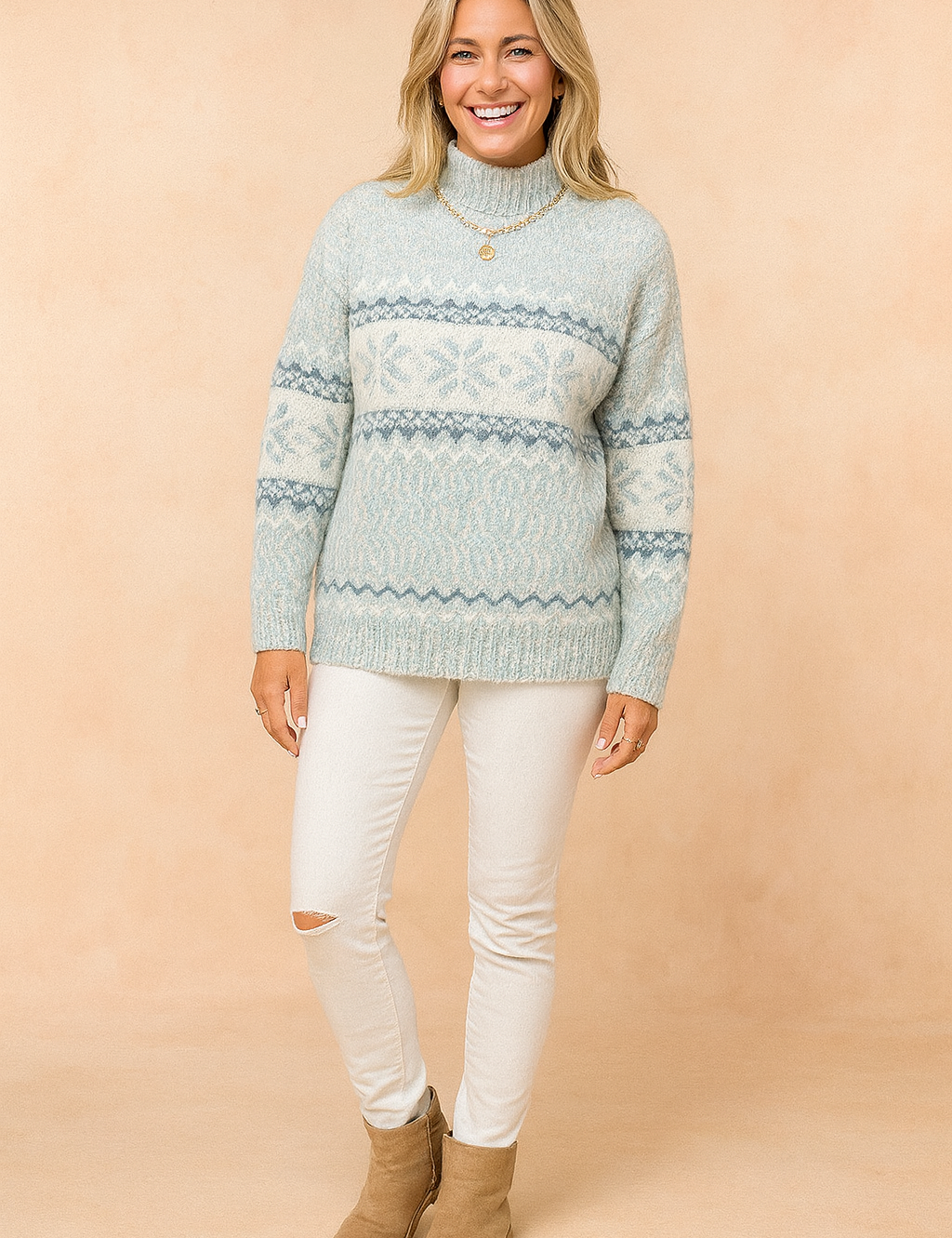 Light blue and white Nordic-patterned knit sweater with high neck, paired with slim white ripped-knee jeans and tan suede ankle boots.