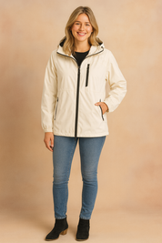Cream hooded zip-up jacket with black zipper accents, styled with slim-fit blue jeans and black suede ankle boots.