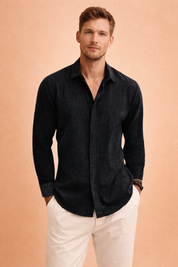 Dark textured long-sleeve button-up shirt with a relaxed open collar, paired with clean straight-leg white trousers for a refined casual look.