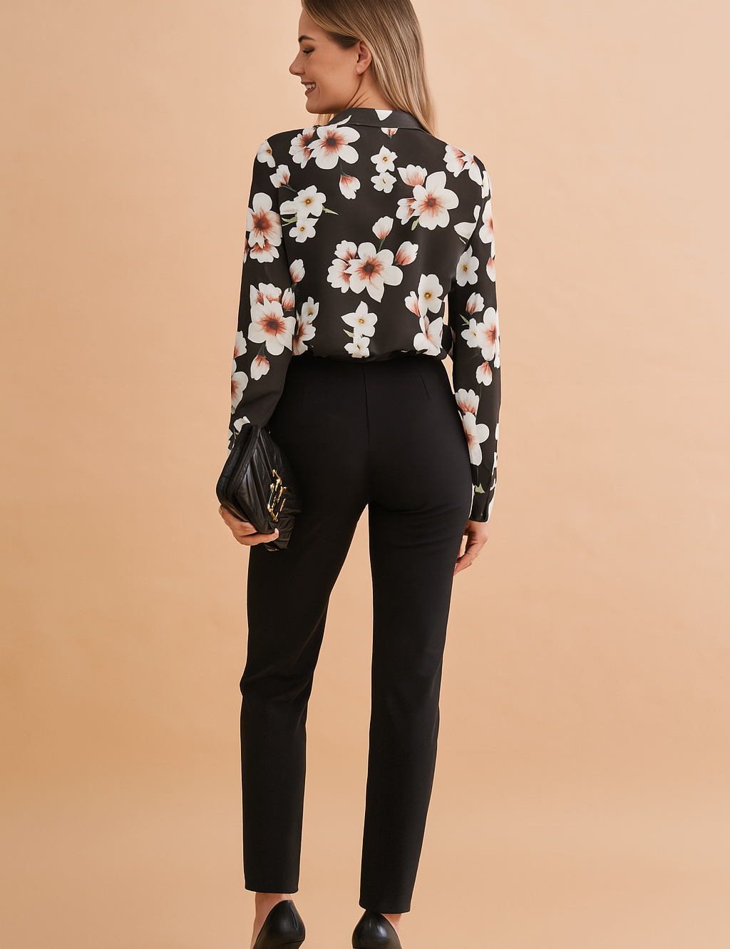 Black long-sleeve blouse with soft white and blush floral print, featuring a relaxed tailored fit and paired with sleek black high-waisted trousers.