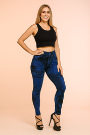 High-waisted blue denim-print leggings with distressed details and a sleek skinny fit, styled with black strappy high heels.