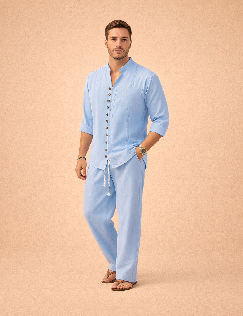 Light blue long-sleeve button-front shirt with a band collar, decorative vertical seam detailing, chest pocket, and rolled cuffs, paired with matching relaxed-fit drawstring trousers and open-toe leather sandals.