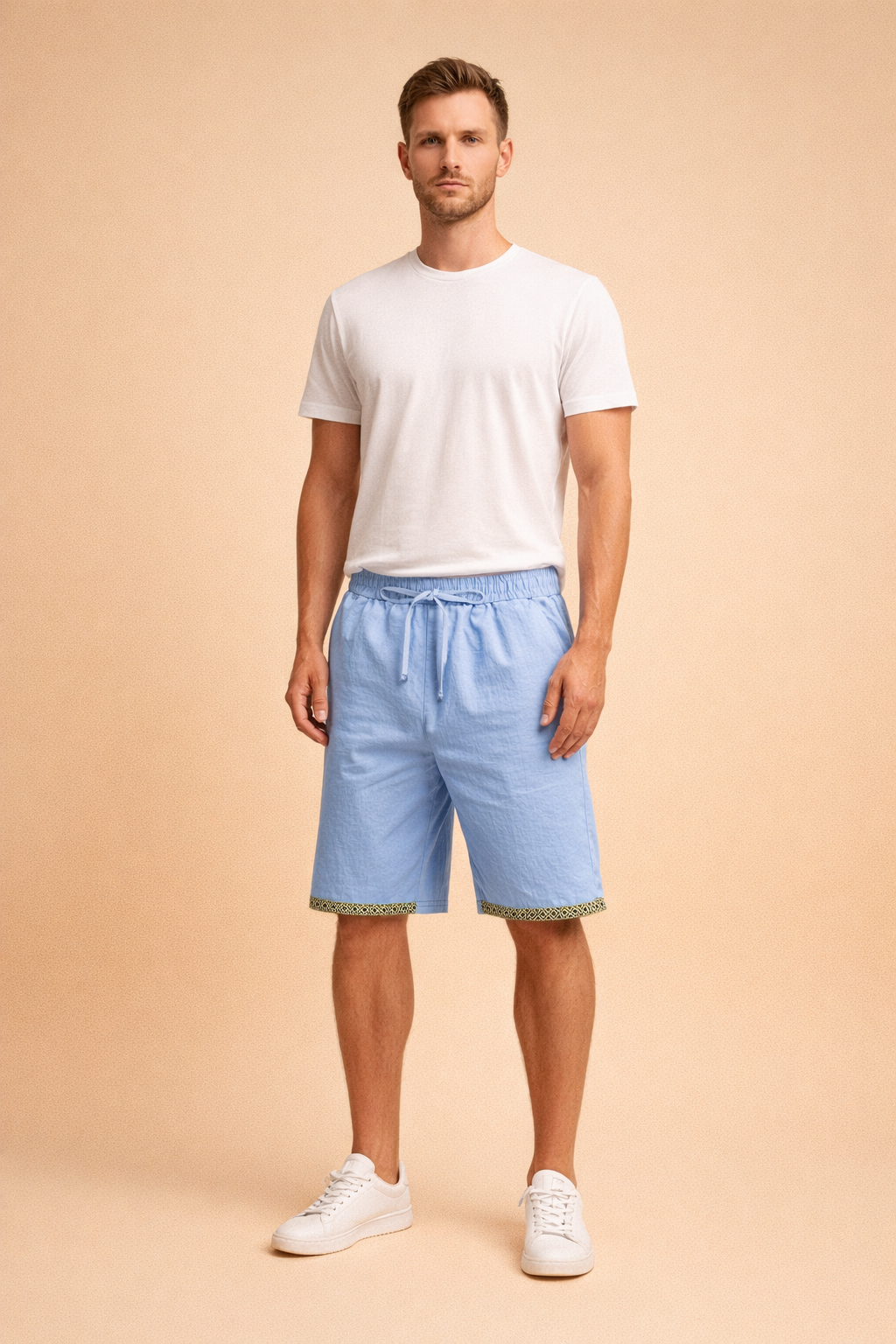 Light blue drawstring summer shorts with elastic waist and geometric hem trim paired with a clean white short sleeve t-shirt and minimalist white low top sneakers, styled for a relaxed European warm weather look