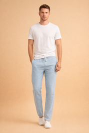 Light blue linen drawstring trousers with a straight slim leg, lightweight breathable fabric, smooth weave texture, clean waistband with adjustable tie, ankle-length cut, paired with minimalist white low-top sneakers.