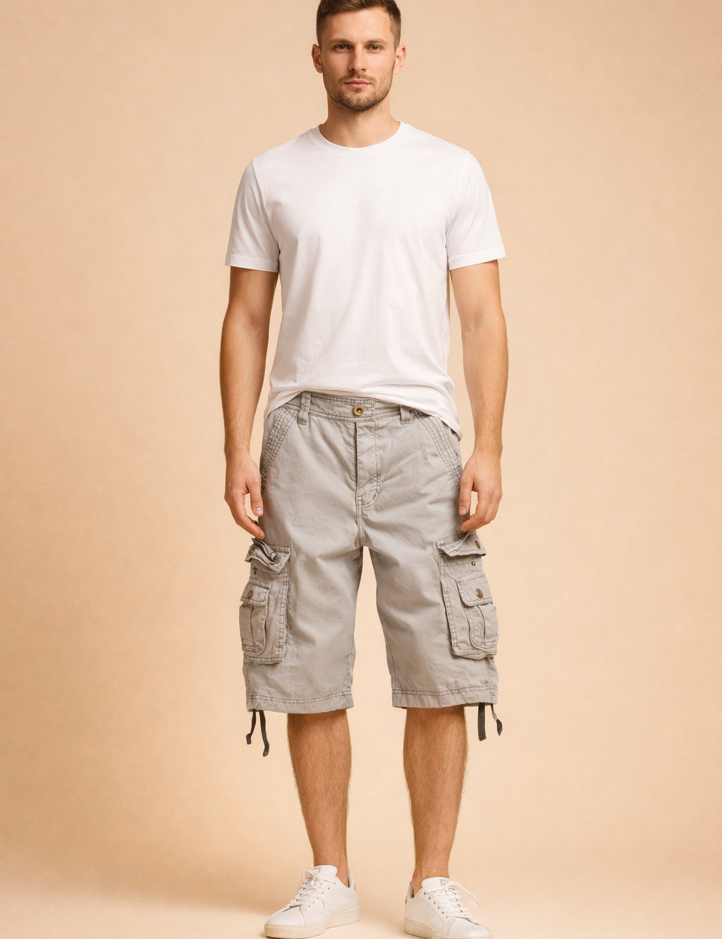 Light grey cotton cargo shorts with multi-pocket utility design, button-flap side pockets, reinforced stitching, adjustable hem drawstrings, paired with a plain white short-sleeve crew-neck T-shirt and clean white low-top sneakers.
