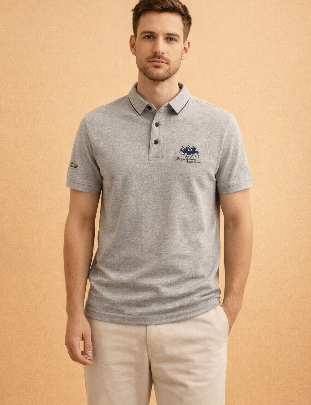 Light grey short-sleeve polo shirt with classic collar, three-button placket, and subtle embroidered chest logo, paired with straight-cut beige trousers for a clean, smart-casual look.