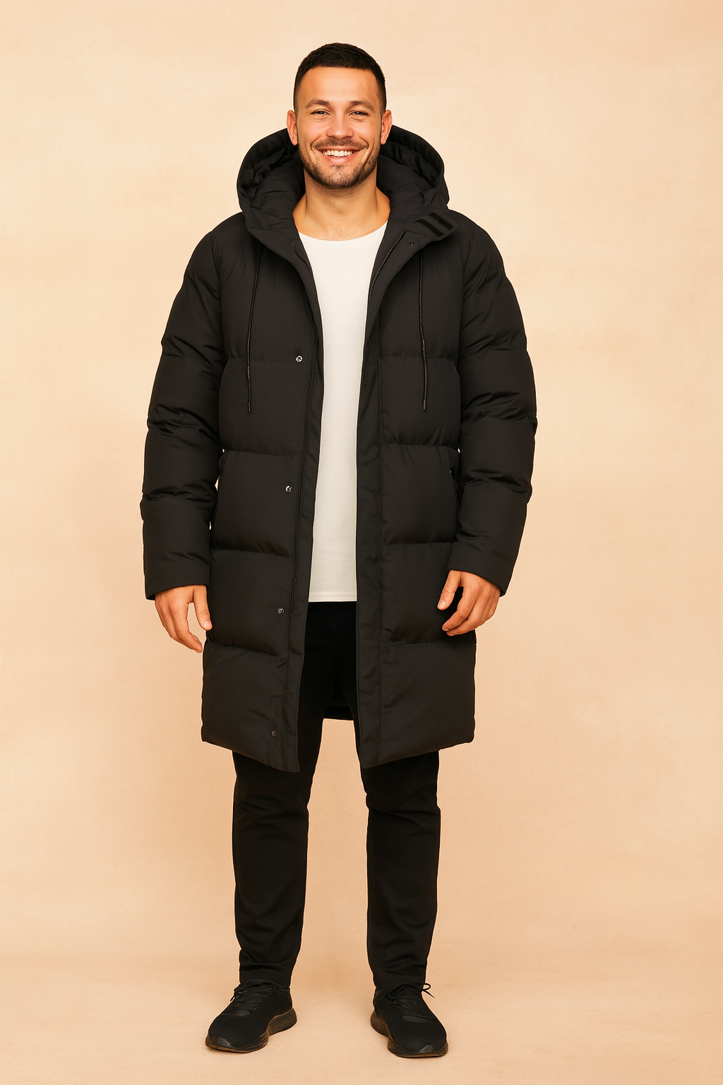 Long black hooded parka jacket with padded quilting and button closure, styled in a casual winter fit.