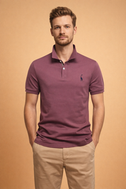 Short-sleeve mauve polo shirt with a classic collar, two-button placket, and subtle embroidered chest detail, paired with tailored beige trousers for a clean, refined casual look.