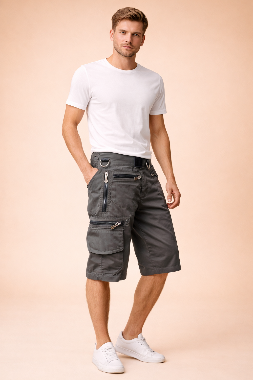 Washed charcoal gray military cargo shorts with a solid matte twill fabric, reinforced stitching, multiple utility pockets, exposed metal zippers, integrated D-ring hardware, and knee-length straight cut, styled with a solid mustard yellow short-sleeve crew-neck cotton T-shirt and clean white low-top athletic sneakers.