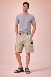Men’s tactical cargo shorts in solid beige with visible ripstop grid fabric texture, straight above-knee length, zip fly with single button closure, reinforced belt loops, multi-pocket utility design with side cargo flap pockets and zip pocket detail, clean stitched hems, and durable outdoor construction.