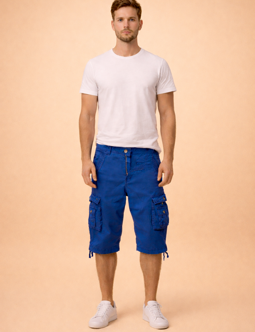 Blue cotton cargo shorts with multiple flap pockets and button details, paired with a plain white short-sleeve crew neck T-shirt and clean white low-top sneakers, showcasing a casual summer outfit with durable fabric texture and structured stitching.