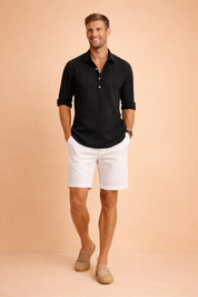 Long-sleeve button-front shirt with a relaxed collar and clean placket, styled with tailored knee-length shorts and minimalist slip-on loafers for a refined warm-weather smart-casual outfit.
