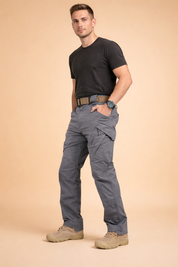 Men’s grey tactical cargo pants with straight-leg cut, reinforced seam panels, multi-functional side pockets with flap and zipper details, structured waistband with belt loops, and durable utilitarian design suitable for everyday wear.