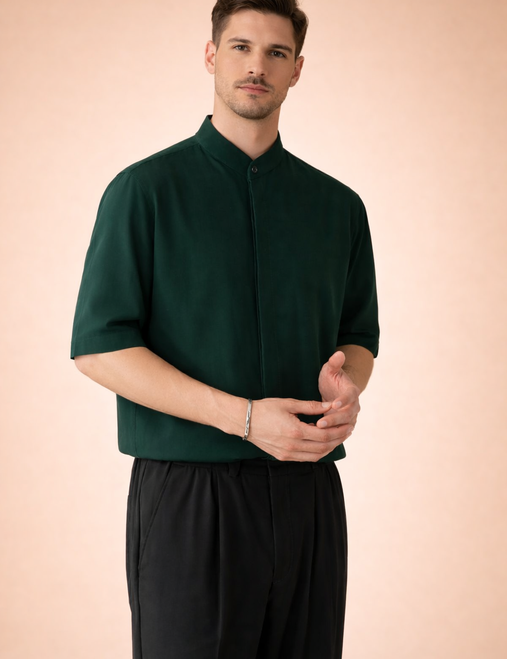 Men’s short-sleeve tailored shirt with a clean mandarin collar, concealed button placket with a single visible top button, smooth structured fabric with a fluid drape, paired with straight-leg trousers featuring a relaxed fit, soft pleating, and a clean waistband finish.
