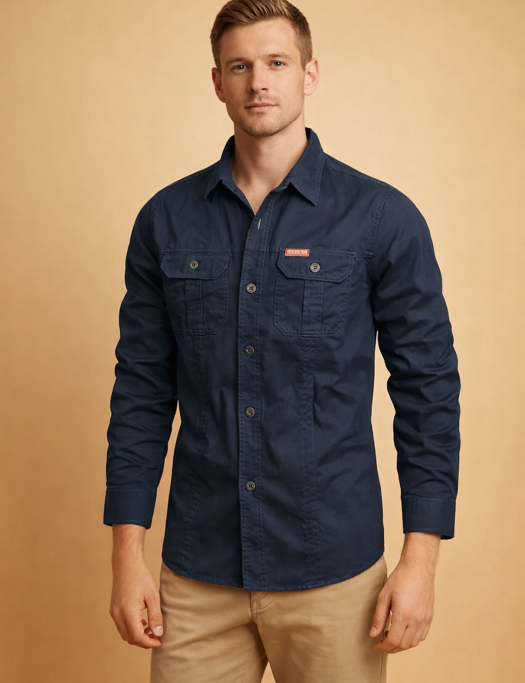 Long-sleeve navy button-down shirt with structured collar, front button closure, dual flap chest pockets, reinforced seams, and tailored fit, paired with straight-cut beige chinos for a clean, modern menswear look.
