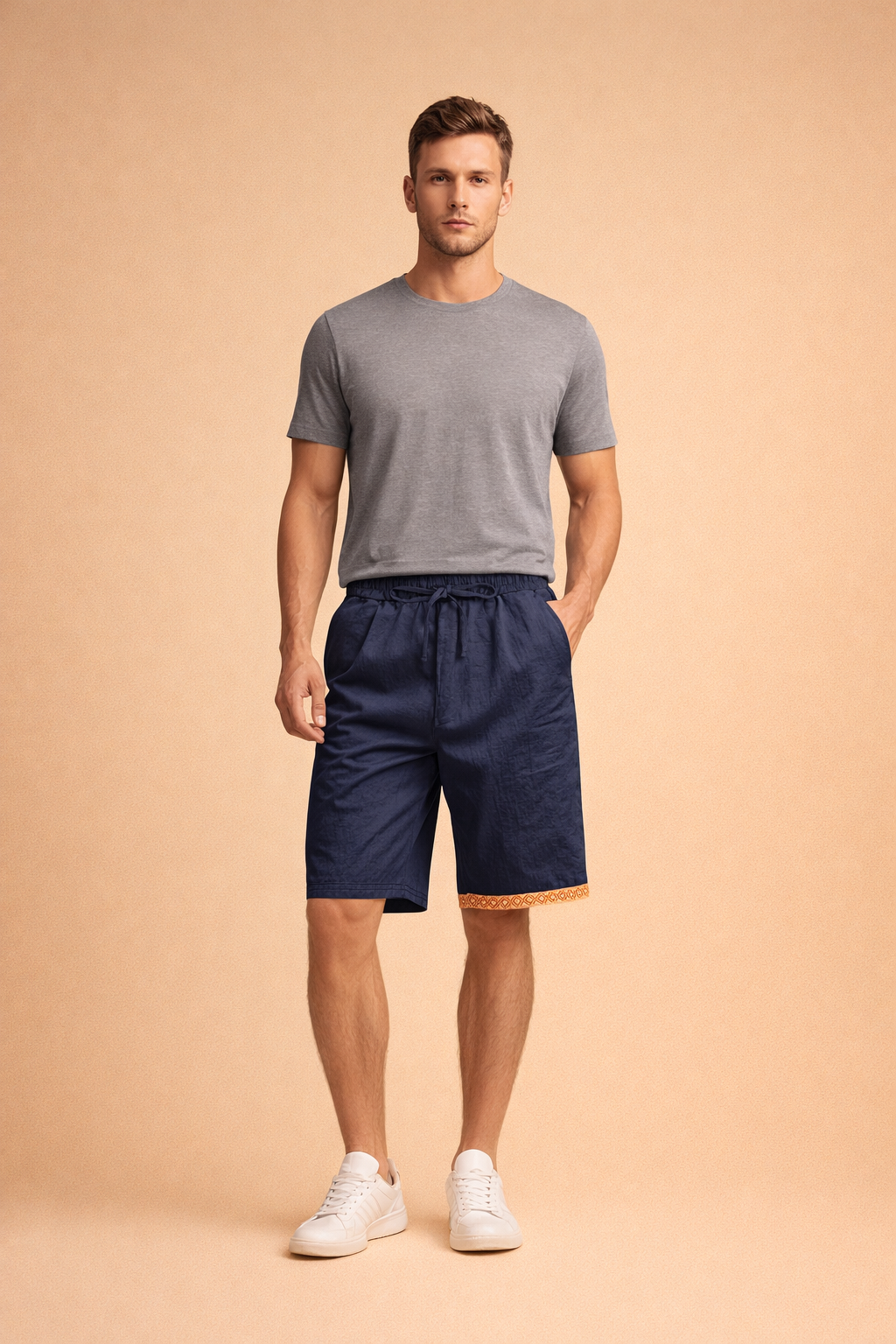 Men’s navy drawstring shorts with a relaxed fit and smooth woven texture, finished with a subtle geometric trim at the hem, paired with a clean short-sleeve crew neck T-shirt and minimalist low-profile sneakers for a modern summer casual look.
