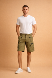 Men’s olive green knee-length cargo shorts with structured fit, multiple utility pockets, zippered side pockets, reinforced seams, and clean straight-leg cut paired with a classic white short-sleeve crew neck T-shirt and minimalist low-profile white sneakers for a modern casual look
