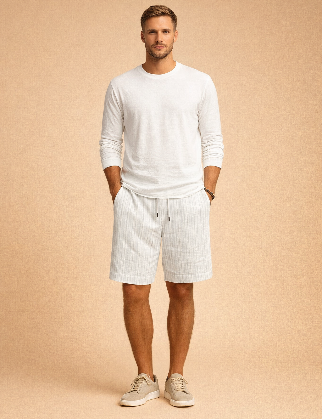 Light summer outfit featuring a relaxed long-sleeve white shirt paired with tailored light sand shorts showcasing a fine vertical textured stripe pattern, finished with a clean elastic waistband and drawstring, styled with minimal neutral footwear for a refined warm-weather look.