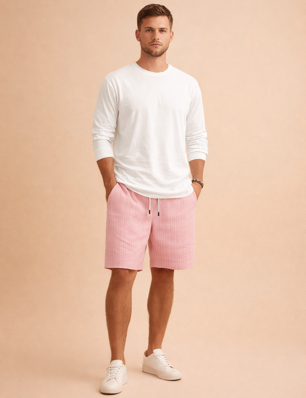 Men’s summer outfit featuring ribbed light pink drawstring shorts with a vertical woven texture, paired with a clean white long-sleeve shirt and minimalist white low-top sneakers, styled in a modern European casual fashion look.