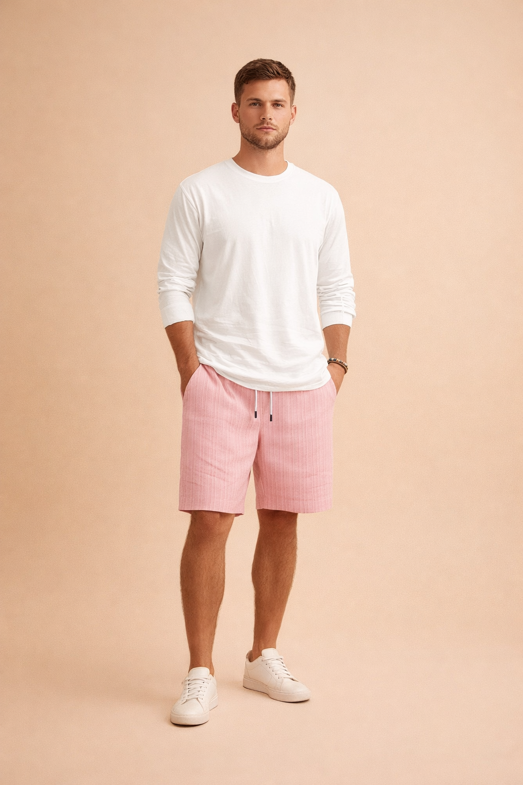 Men’s summer outfit featuring ribbed light pink drawstring shorts with a vertical woven texture, paired with a clean white long-sleeve shirt and minimalist white low-top sneakers, styled in a modern European casual fashion look.