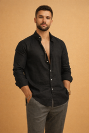 Men’s tailored long-sleeve black button-front top with a clean structured collar, smooth refined finish, relaxed fit, and paired with slim straight-leg trousers for a modern polished look.
