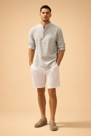 Light grey and white vertically striped textured long sleeve mandarin collar shirt with button placket and roll-tab sleeves, paired with crisp white tailored trousers for a refined casual menswear look