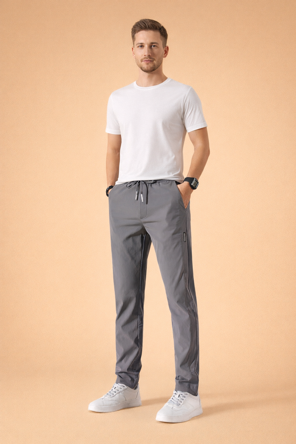 Men’s minimalist white short-sleeve t-shirt paired with straight-leg gray drawstring pants and clean white low-top sneakers, styled for a modern casual everyday look.