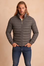 szara męska kurtka pikowana, zapinana na zamek błyskawiczny, z wysokim kołnierzem i dopasowanym krojem