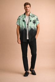 Mint green to black gradient short-sleeve button-up shirt with black floral print, worn open over a plain white crew-neck T-shirt, paired with slim black trousers and black leather loafers, featuring a smooth lightweight fabric with precise fade transition and sharp floral detailing.