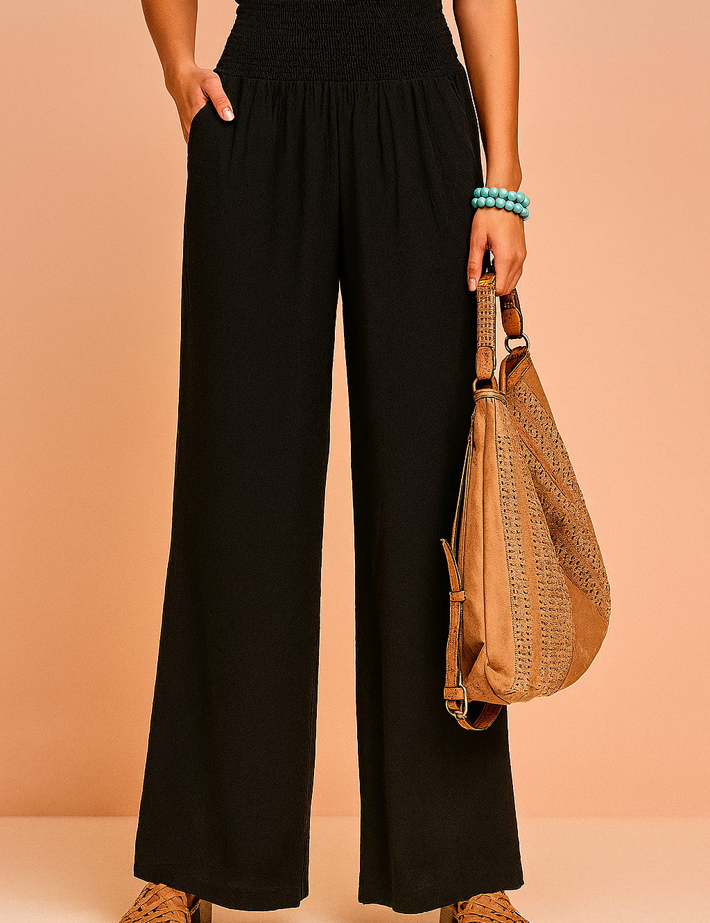 High-waisted wide-leg black smocked pants styled with tan woven sandals and a textured tan leather handbag.