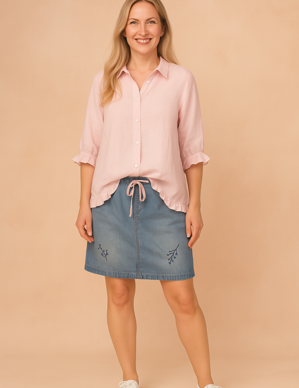 Light pink button-up blouse with ruffled hem and cuffs, paired with a blue denim skirt featuring subtle floral embroidery.