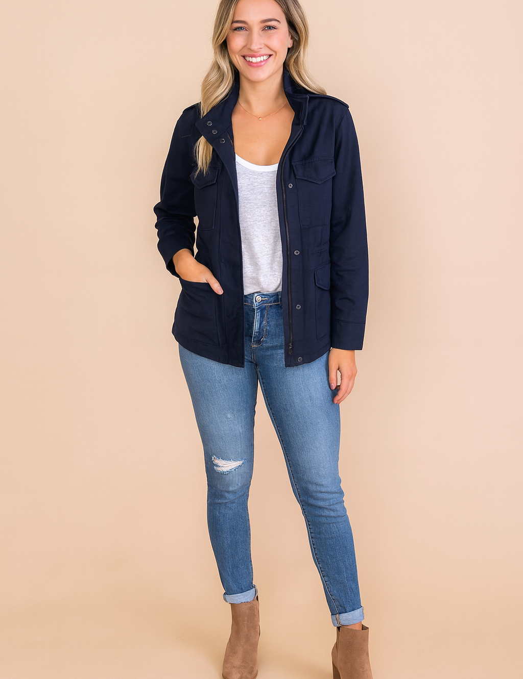 Navy casual zipper utility jacket with front flap pockets, button closure, and long sleeves styled with a white T-shirt and blue jeans.
