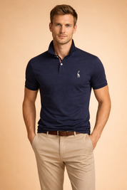 Classic navy short-sleeve polo shirt with a structured collar, two-button placket, subtle embroidered chest logo, paired with tailored beige chinos and a brown leather belt for a clean smart-casual look.